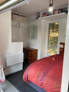 OhauitiThe Treehut的一间卧室配有一张床、一张书桌和一个窗户。
