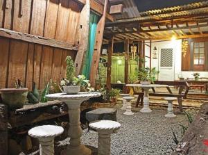 BantaoayRedDoorz Hostel @ Deomar Hometel & Farm Cafe Ilocos Sur的天井配有桌椅和长凳