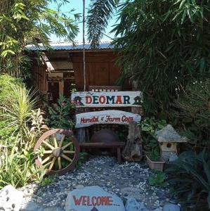 BantaoayRedDoorz Hostel @ Deomar Hometel & Farm Cafe Ilocos Sur的花园里的迎宾标志和水轮