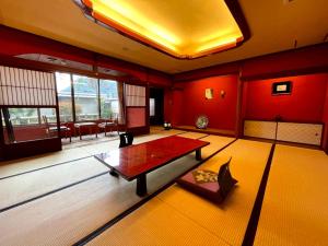 武雄市京都亚酒店的客厅设有红色的墙壁和桌子