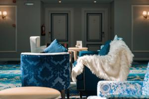 欧奈宰Gulanar Hotel的客厅配有蓝色和白色的椅子