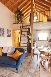 阿古洛Sustainable Rural House La Lisa Dorada的客厅设有蓝色的沙发和楼梯。
