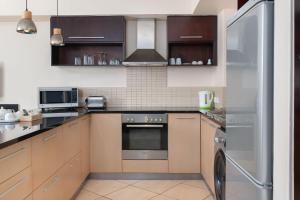 开普敦地标豪华公寓的厨房配有不锈钢用具和棕色橱柜
