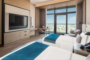 迪拜Paramount Hotel Midtown的配有一张床和一台平面电视的酒店客房