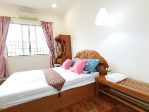 诗巫NanSang One Homestay 8pax 4Rooms的一间卧室配有带粉红色和蓝色枕头的床