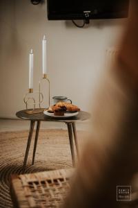 杜斯堡Guesthouse in het Voorhuys的一张桌子,上面有两根蜡烛和一盘食物