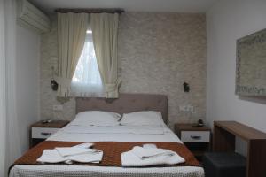 比于卡达玛萨旅馆的一间卧室配有一张带白色毛巾的床