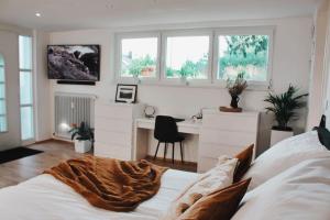 加格瑙Smart-Apartment BlickWinkel Schwarzwald的卧室配有一张床、一张书桌和窗户。