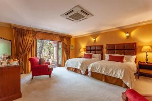 贝拉贝拉Lejwe La Metsi Private Reserve的一间大卧室,配有两张床和红色椅子
