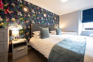 MorebattleTemplehall Hotel的一间卧室配有一张带花卉壁纸的床