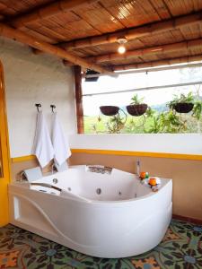 圣罗莎德卡瓦尔FINCA HOTEL DON JULIO的窗户客房内的白色大浴缸