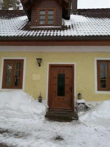 Rohr im GebirgeApartment Nazbauerhof的雪中带木门的房子