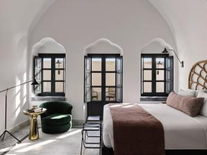 易莫洛林La Maltese Estate的一间卧室配有一张床和一把绿色椅子