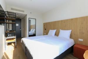 鹿特丹Fletcher Hotel Rotterdam-Airport的卧室配有一张白色大床