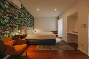 蓬塔德尔加达Azores Inn - Family Suites的一间卧室配有一张床和花卉壁画