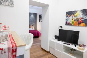 塔兰托Eutuxia的客厅配有白色橱柜上的平面电视