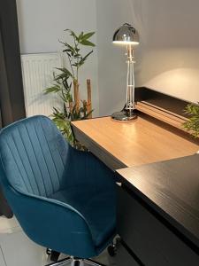 弗罗茨瓦夫GREEN 25 - Angel River的一张蓝色椅子,坐在桌子旁,带灯
