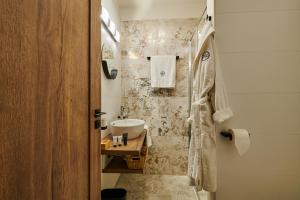 奥洛穆茨Hotel Alfréd a Hermína的浴室配有水槽和带水槽的淋浴