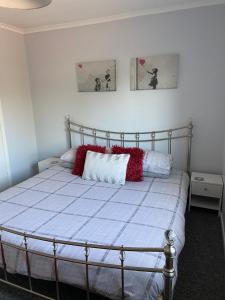 KentPalmbeach Place的一间卧室配有一张带红色枕头的床