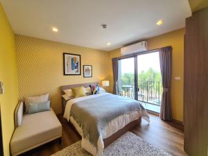 华欣Huahin mountain view room near the beach的卧室配有床、椅子和窗户。