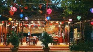 吉仙Thuy Tien Ecolodge的餐厅设有桌椅和色彩缤纷的灯笼