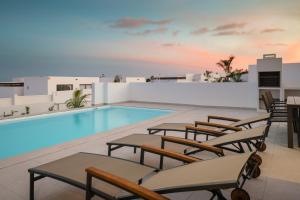 普拉亚布兰卡Villas Altos de Lanzarote的一个带躺椅的游泳池和一个游泳池