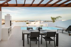 普拉亚布兰卡Villas Altos de Lanzarote的一个带桌椅的庭院和一个游泳池