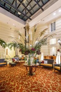 华沙波洛尼亚宫大酒店的大堂配有沙发和鲜花桌