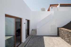 普拉亚布兰卡Villas Altos de Lanzarote的白色的房子,设有楼梯和玻璃门