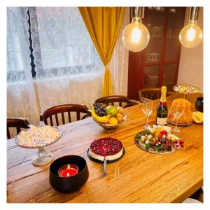 沃利乌格乡Vila Montana Valiug的一张木桌,放着一碗水果和葡萄酒瓶