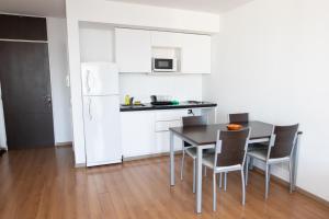 罗萨里奥BriDan的厨房配有桌椅和白色冰箱。