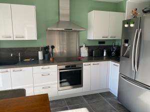 PeriVilla Ghjuvan - Sea, Mountain & Spa的厨房配有白色橱柜和不锈钢冰箱