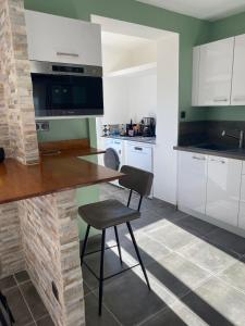 PeriVilla Ghjuvan - Sea, Mountain & Spa的厨房配有白色橱柜、桌子和椅子