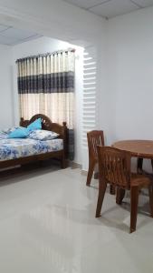 卡卢特勒Anura Home Stay的卧室配有一张床和一张桌子及椅子
