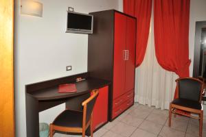 莱尼亚诺拉库尔苏酒店的一间设有书桌和红色橱柜的客房