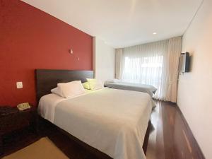 波哥大Apartasuites BellHouse Bogotá的一间设有大床和窗户的酒店客房