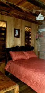 昆卡Estancia Lolita (Cabaña en Cuenca)的一间卧室配有一张红色棉被的床