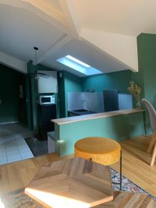 鲁昂Magnifique Appartement Neuf Vieux Rouen的厨房设有绿色的墙壁和木桌