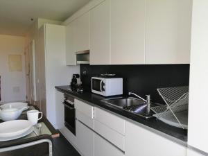 里斯本Welcome Here - Tamisa - Parque das Nações的白色的厨房配有水槽和微波炉