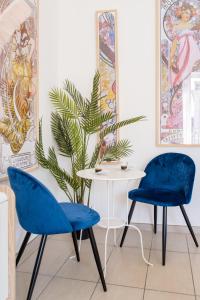 巴科利Naro Suites and Rooms的两把蓝色的椅子和一张桌子,一个植物