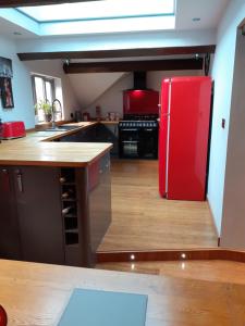 布由德利Riverside 2 bed apartment Bewdley Worcestershire的铺有木地板,配有红色冰箱的厨房