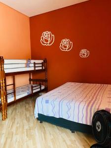 迈里波朗SÍTIO MARAVILHOSO EM MAIRIPORÃ opção de 1 quarto para 8 pessoas ou 4 quartos acima de 9 pessoas的一间卧室设有两张双层床,拥有橙色的墙壁。