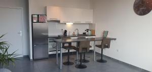 图尔昆Appartement-chic parking privé的厨房配有桌子和冰箱