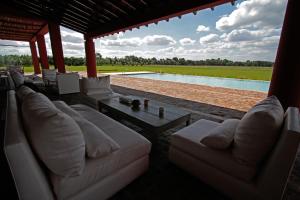 圣安东尼奥德阿雷科Pampas de Areco Resort de Campo & Spa的带沙发和桌子的客厅以及游泳池。