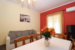 卡诺尼A Nice Apartment- Corfu Town, Kanoni的客厅配有沙发和鲜花桌