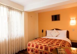 库斯科Laramani Hotel Boutique的一间卧室设有一张床和一个窗口