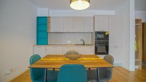 布拉索夫HVA Premium Apartments的厨房配有木桌和蓝色椅子