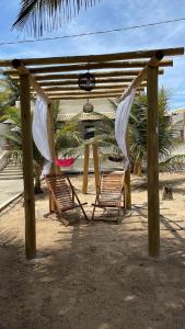 巴拉杜斯科凯鲁斯Casa de Praia - Aracaju - Jatobá的海滩凉棚下的两把椅子