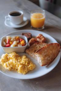 布希奥斯Selina Buzios的包括鸡蛋烤面包和一碗水果的早餐食品