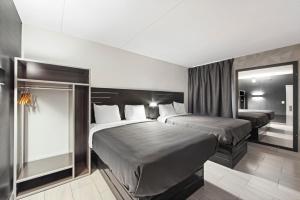 皇后区Casa Azul Hotel Blu-UBS Arena的酒店客房,设有两张床和镜子